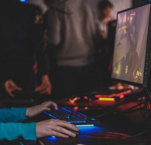 Gamer playing on a PC in a crowd