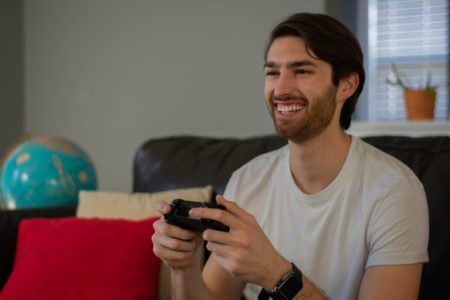 Man smiling and playing a video game