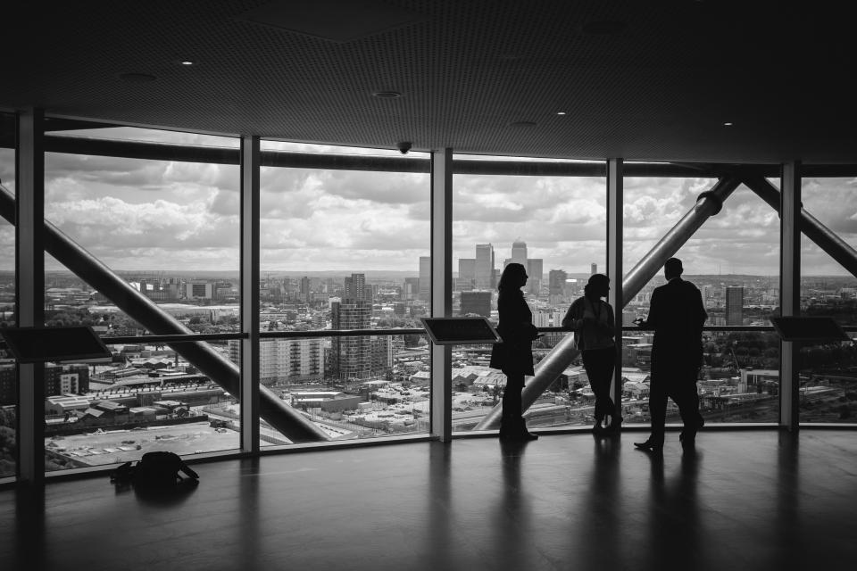 Group of people networking with a skyline behind them.