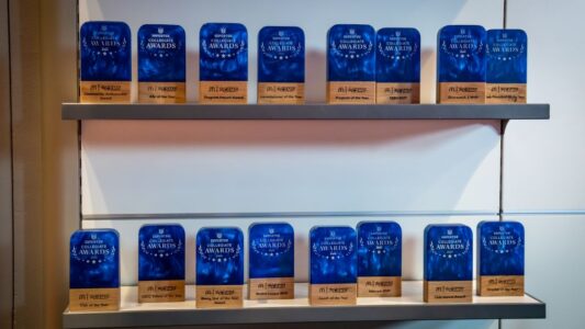 Each of the CECC Texas 2024 Collegiate Awards trophies on shelving.